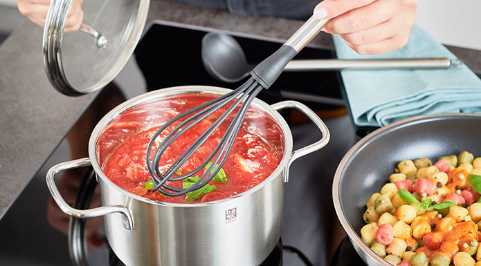 Basic Line Schneebesen rührt Tomatensuppe im Topf um