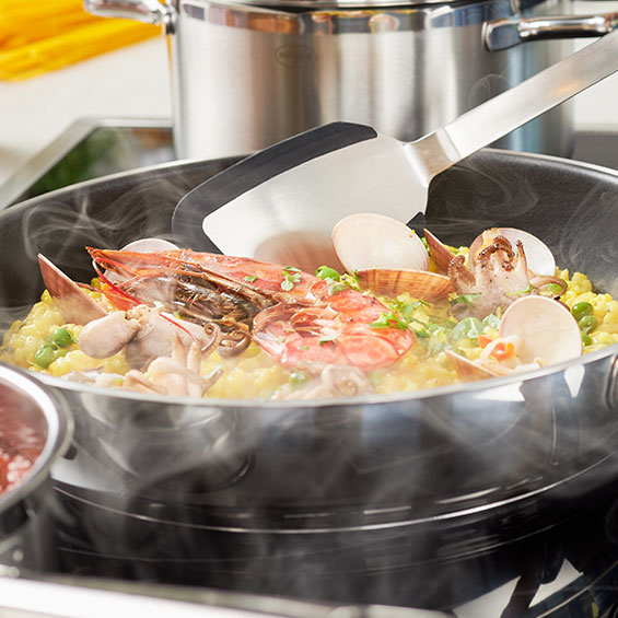 wenden des Paellas mit dem Pfannenwender Silikon