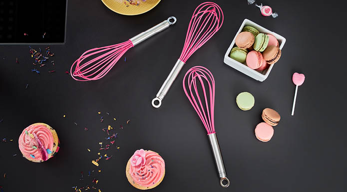 Schneebesen Pink Charity Schneebesen Pink Charity und Macarons auf einem Tisch