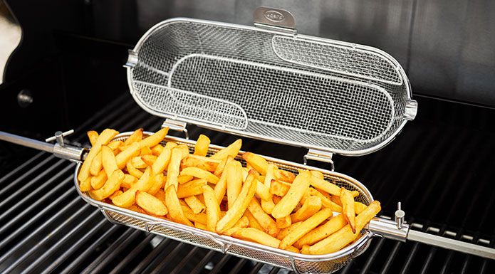 Pommes im Drehspießkorb auf dem Grill
