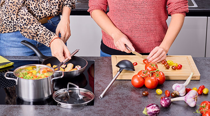 Kochgeschirrserie Basic Line Zwei Frauen kochen gemeinsam in den Töpfen und mit den Messern der Serie Basic Line
