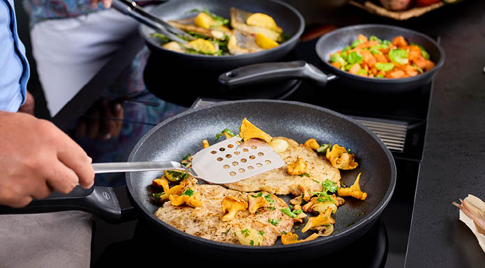 Kochen in den Cadini Bratpfannen mit der Pfannenschaufel gelocht