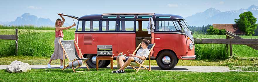 Gasgrill BBQ-Portable Videro G2-P Paar mit VW-Bus und Gasgrill BBQ-Portable Videro G2-P am grillen